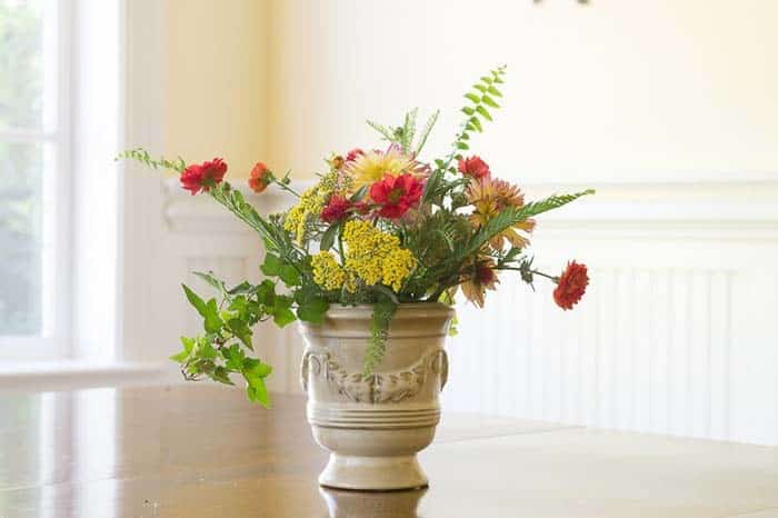 Red and Yellow Flowers Pop in Creamy Vase