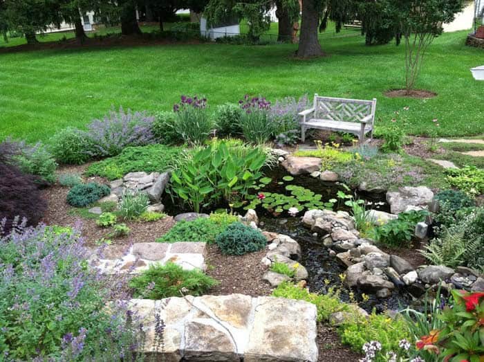 Add Seating and a Flood-Preventing Pond to Sloping Yard