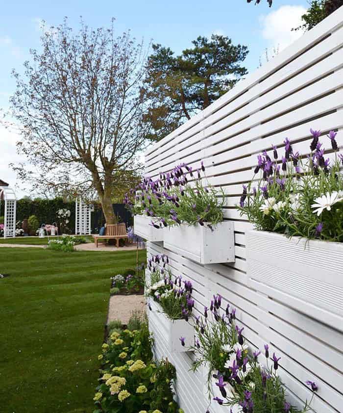 Built-In Window Boxes Add Color To A White Fence