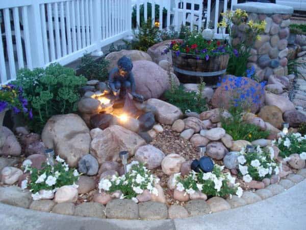 Whimsical Rock Garden with Toy Sailboat and Flower Barrel