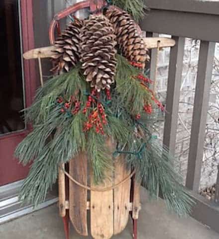 Elevate a Rustic Sleigh Decor with Pine Cones and Fir