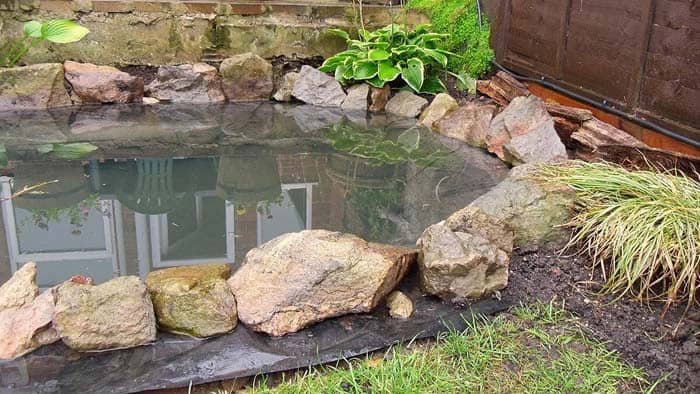 Cover Your Hand-Dug Pool with a Liner and Large Rocks